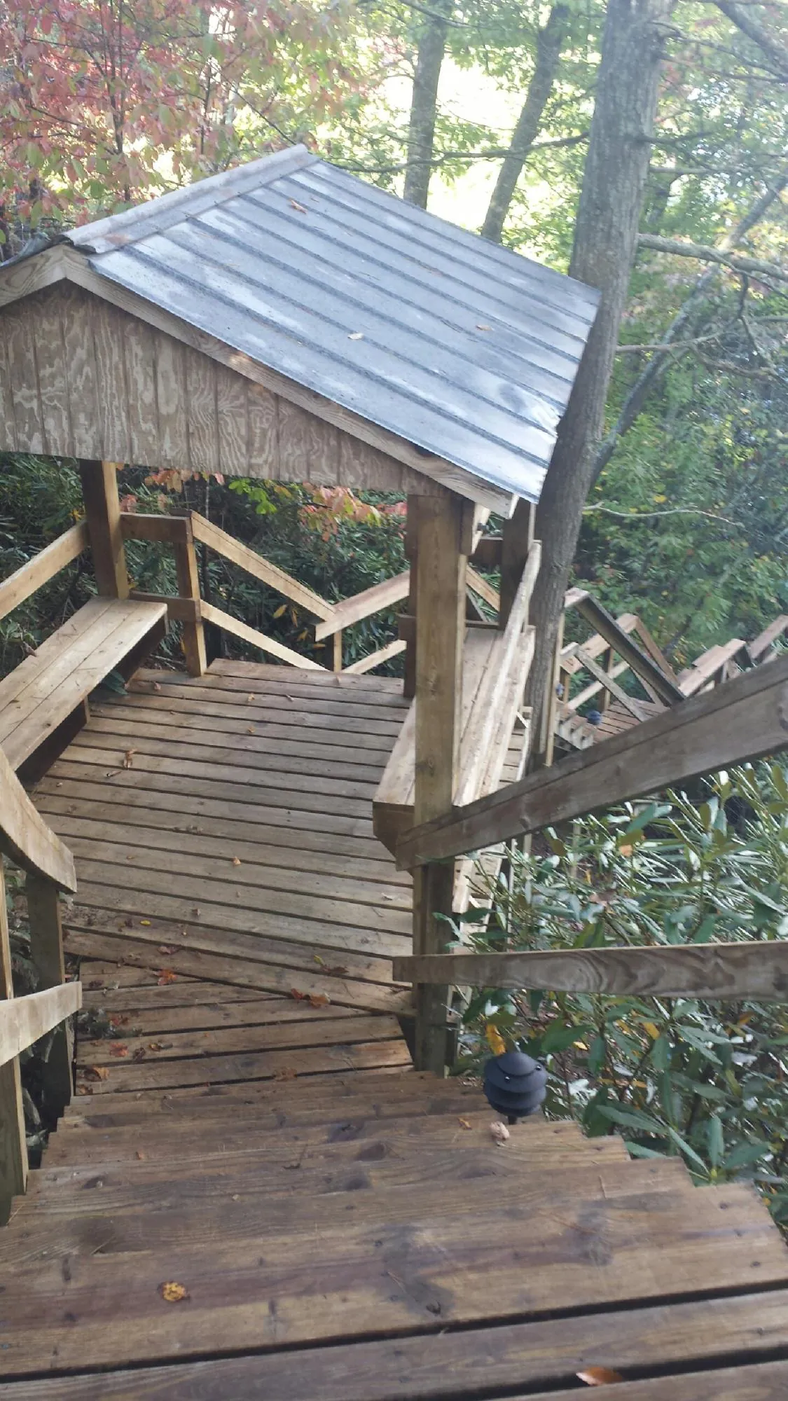 Metal roofed shelter over wooden steps on a wooded walkway — Skylight Repair & Installation work by our crew in Harrisburg